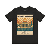 A black short-sleeve crewneck t-shirt featuring a vintage-style graphic print of the Library of Alexandria on the chest. The graphic has a beige background with a stylized sunburst, blue water, and classical architecture.
