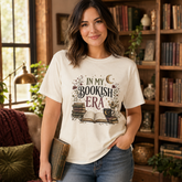 A woman wearing a cream-colored graphic t-shirt that reads &