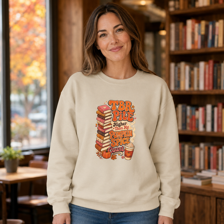 A woman wearing a cream-colored crewneck sweatshirt with a &