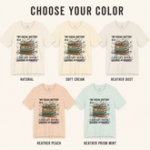 A color selection graphic for a graphic T-shirt showing five shirt color variants under the heading &