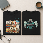 Two folded black T-shirts displayed side by side on a light beige fabric background, styled with a stethoscope, notebook, and coffee mug. The front shirt features a medical-themed graphic with books, a stethoscope, pills, and a coffee cup, with the text &