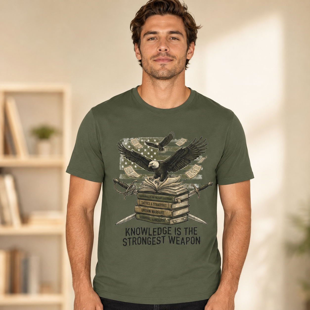 A man wearing an olive green graphic t-shirt with a design of an eagle over books and a dollar bill, with the text &