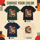 A color selection graphic for a graphic T-shirt showing four shirt color options: forest green, black, navy blue, and natural white. Each shirt features a retro-style book graphic with the text &