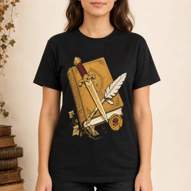 A woman wearing a black short-sleeve t-shirt with a graphic print of an antique gold book, a silver sword, and a feather quill on the front, set against a warm beige background with a stack of old books on the side.