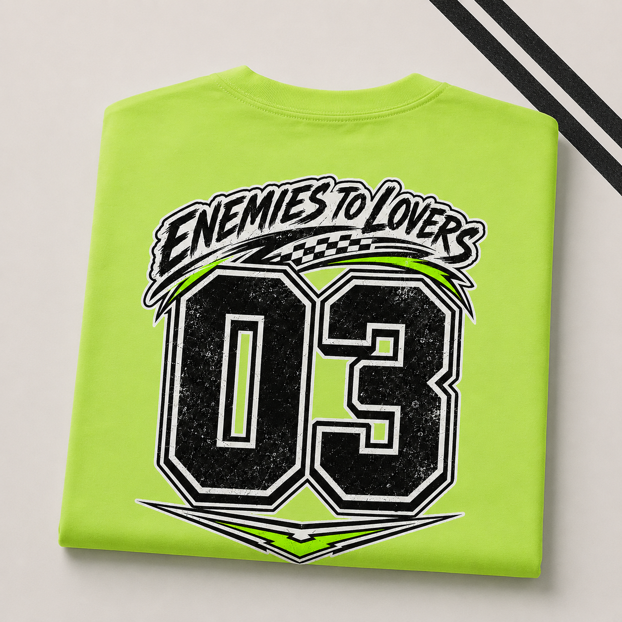 A folded lime green t-shirt with a distressed graphic print featuring the text &