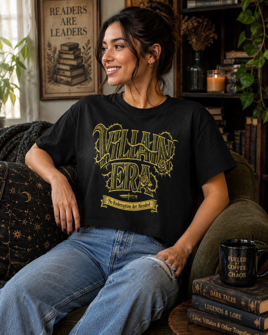 A woman sitting on a couch wearing a black graphic t-shirt with &