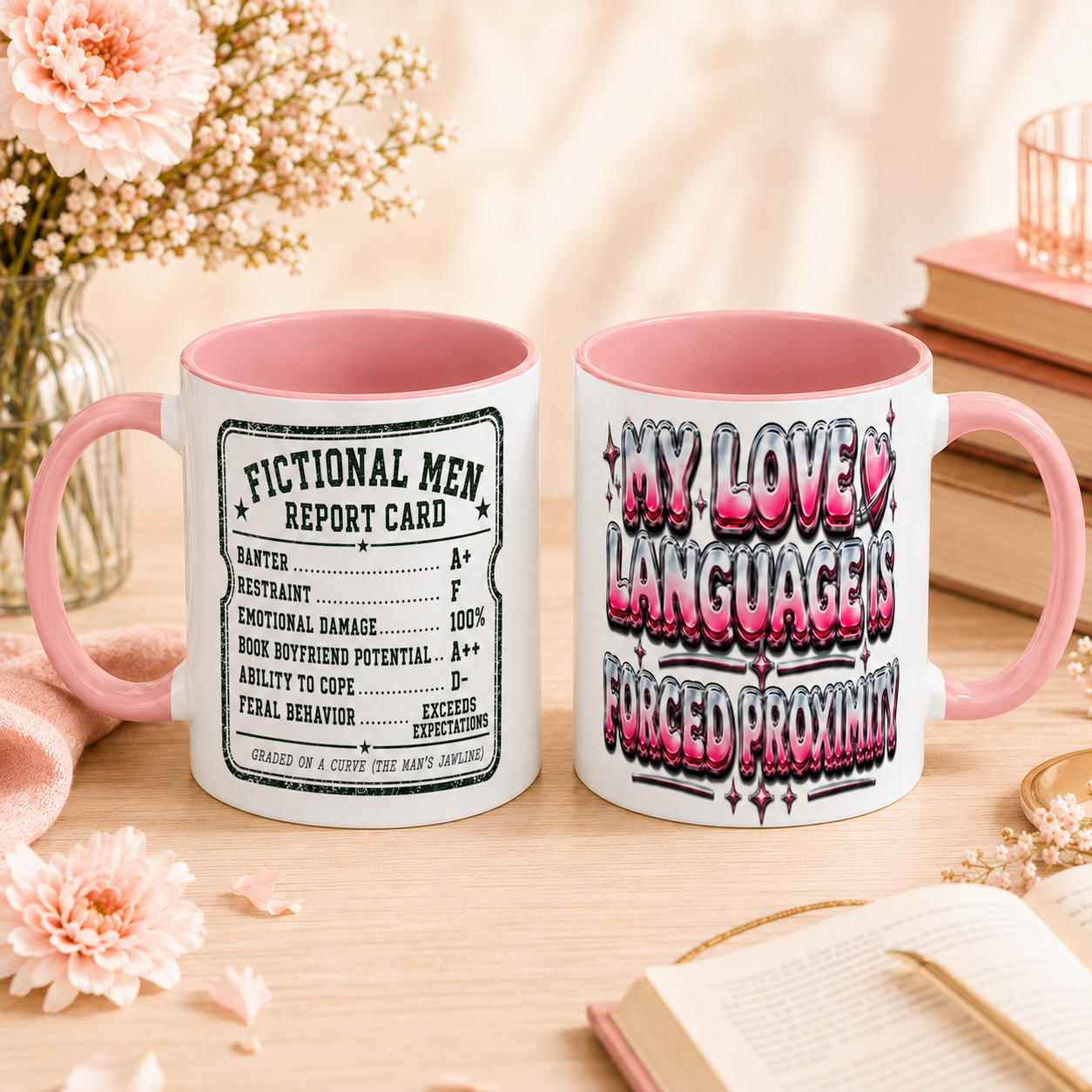 Two white ceramic mugs with pink interiors and handles are shown on a wooden table in a styled setting with flowers, books, and an open book. One mug has a black vintage-style report card design reading &