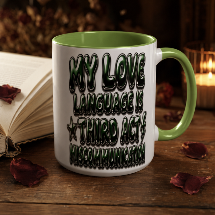 A white ceramic mug with a light green handle and interior, featuring the text &