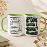Two white ceramic mugs with green handles and interiors, styled on a beige tabletop with books and dried leaves. One mug shows a vintage-style report card design reading &