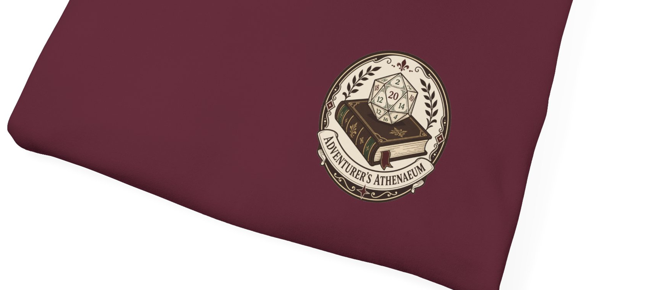 A close-up of a dark maroon fabric item, likely a sleeve or pouch, featuring a circular printed emblem with a book, a 20-sided die, and the text &