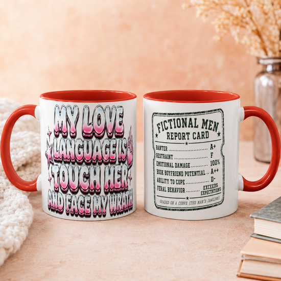 Two white ceramic mugs with red handles and interiors are shown side by side on a beige tabletop. The left mug has large pink, black, and white text reading &