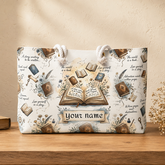 A white canvas tote bag with a vintage book-themed print, featuring rope handles and a customizable name banner, displayed on a wooden shelf against a textured beige wall.