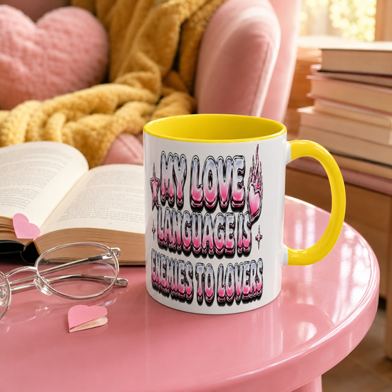 A white ceramic coffee mug with a bright yellow handle and interior, featuring the text &