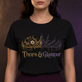 A woman wearing a black short-sleeve graphic T-shirt with a decorative crown design and the words &