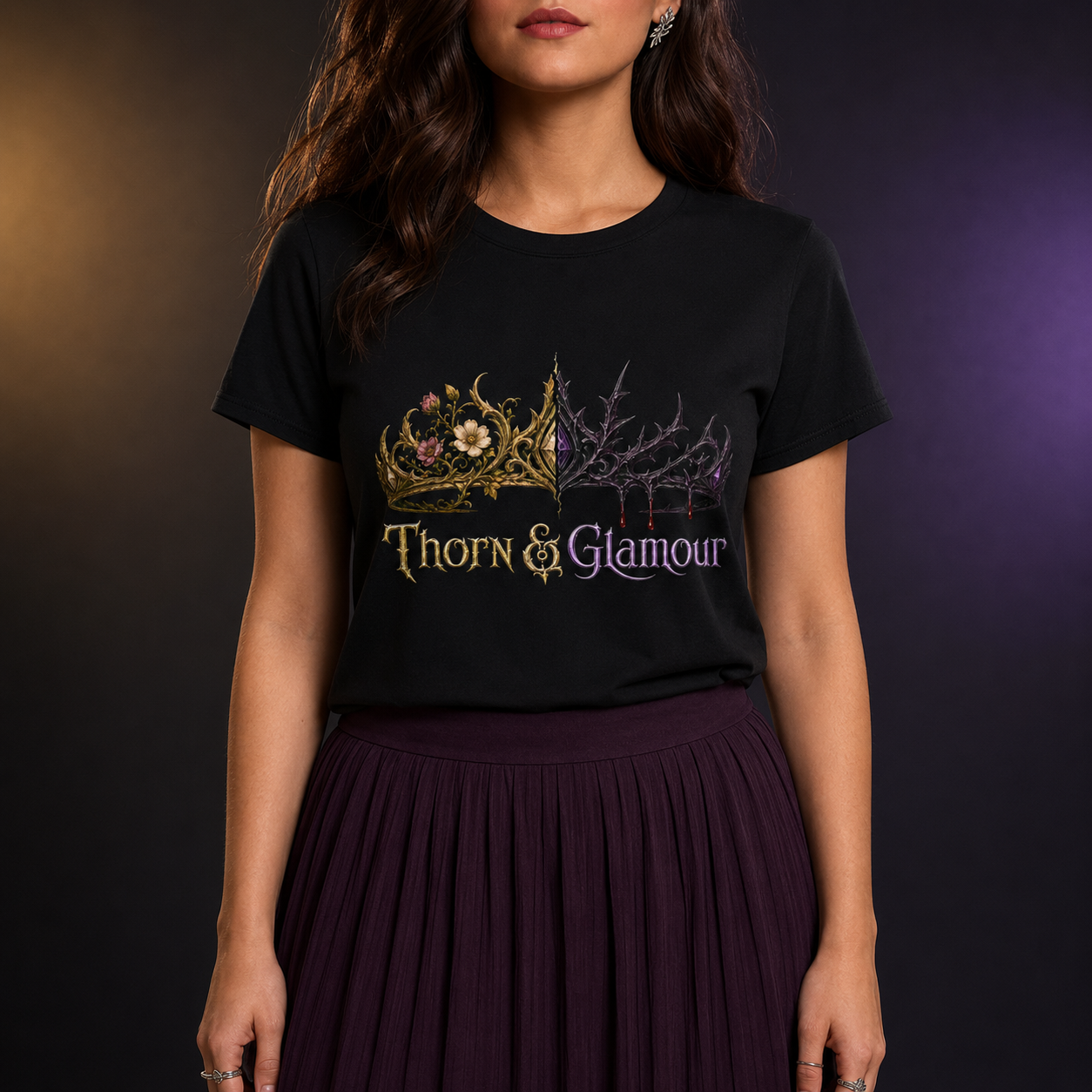 A woman wearing a black short-sleeve graphic T-shirt with a gold and purple gothic crown design and the text &