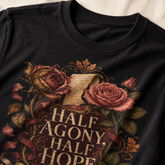 Close-up of a black crewneck t-shirt featuring a vintage-style graphic with roses, a scroll, and the text &