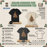 A Gildan bookworm tee color choice infographic showing black and natural heather fabric options with a Christmas tree graphic, care instructions, sizing guide, and design details on a light wood background.