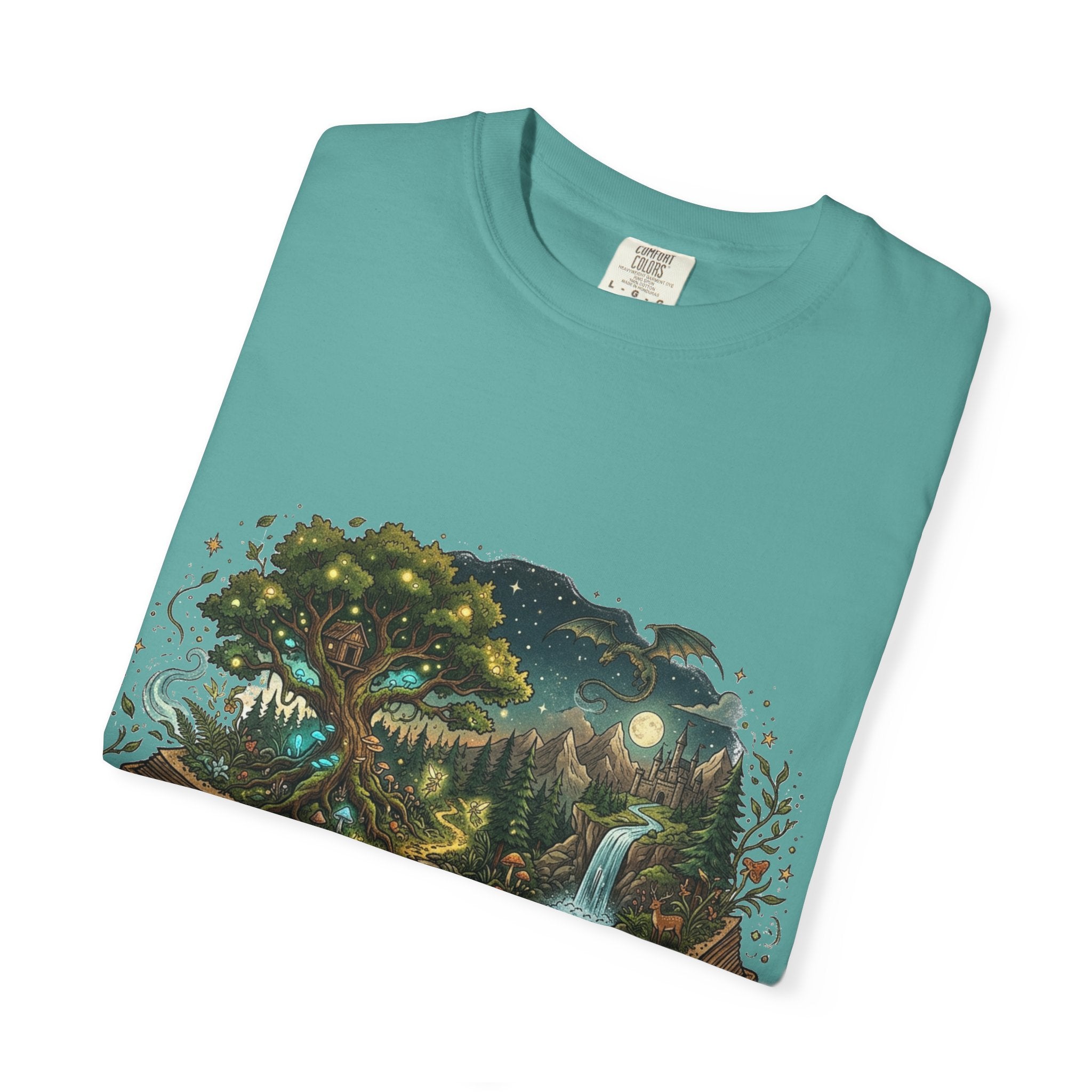 Fantasy book lover tee featuring an enchanted forest, waterfall, and castle emerging from an open book.