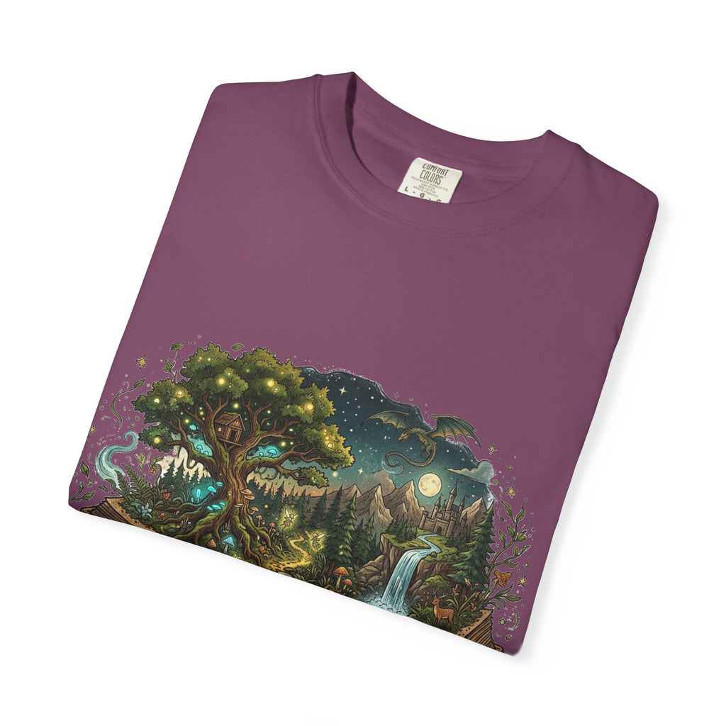 Fantasy book lover tee featuring an enchanted forest, waterfall, and castle emerging from an open book.