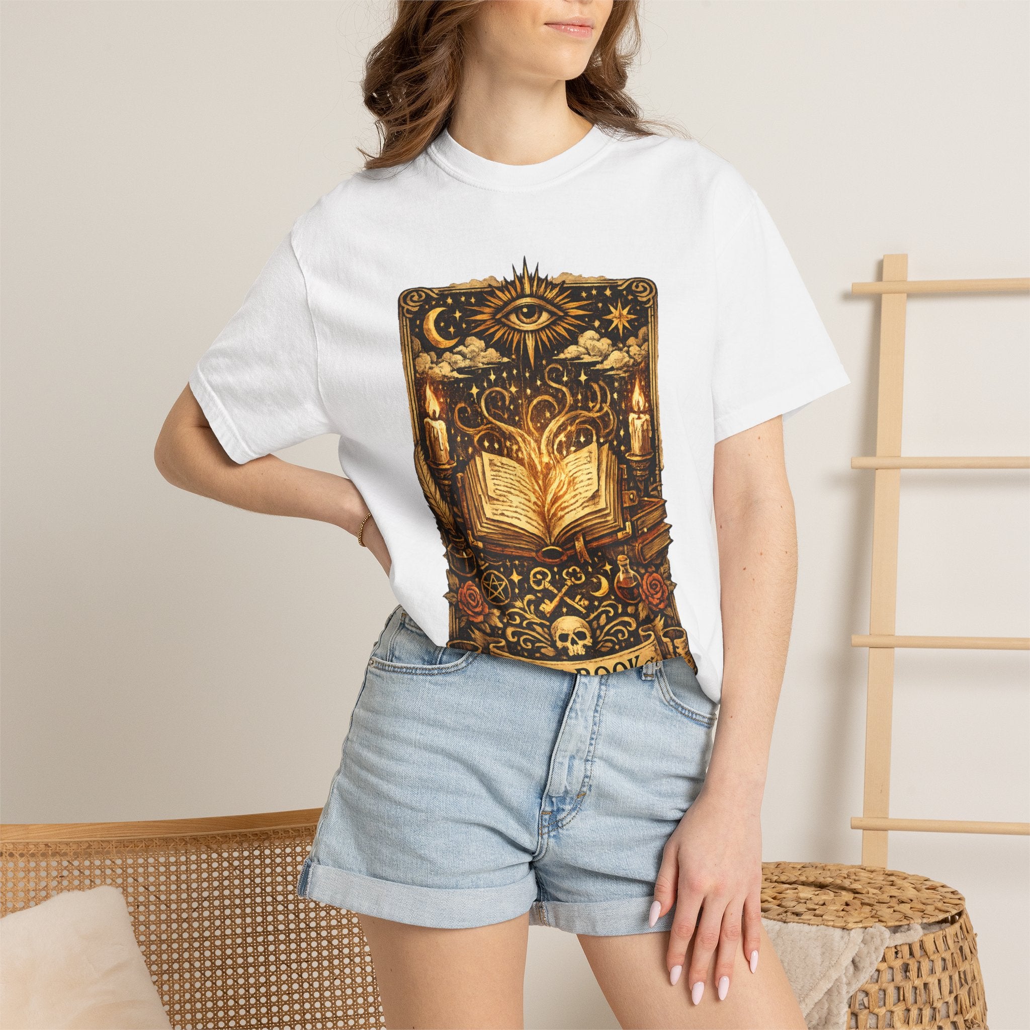 Person wearing a white t-shirt with a black and gold graphic design, standing against a neutral background.