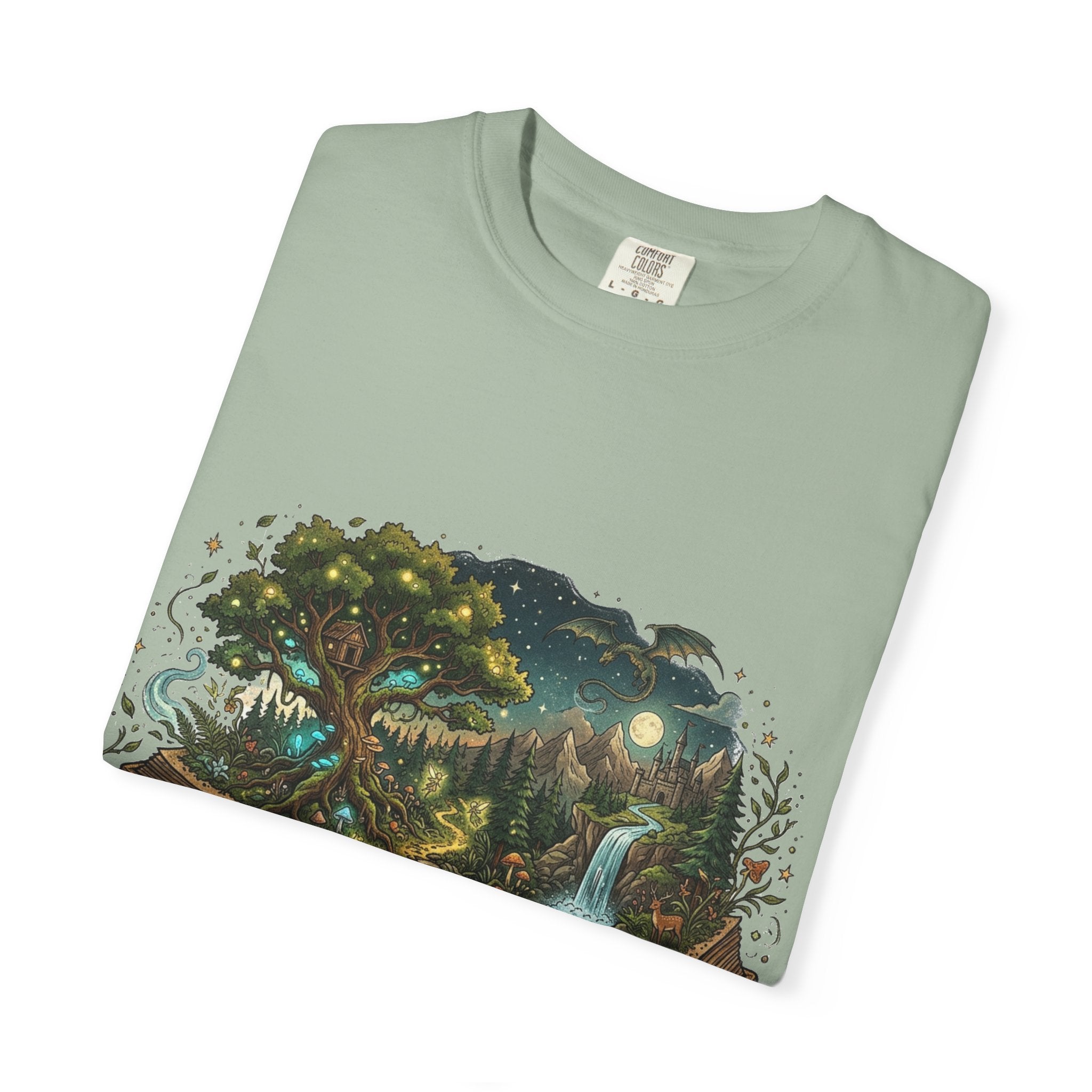 Fantasy book lover tee featuring an enchanted forest, waterfall, and castle emerging from an open book.