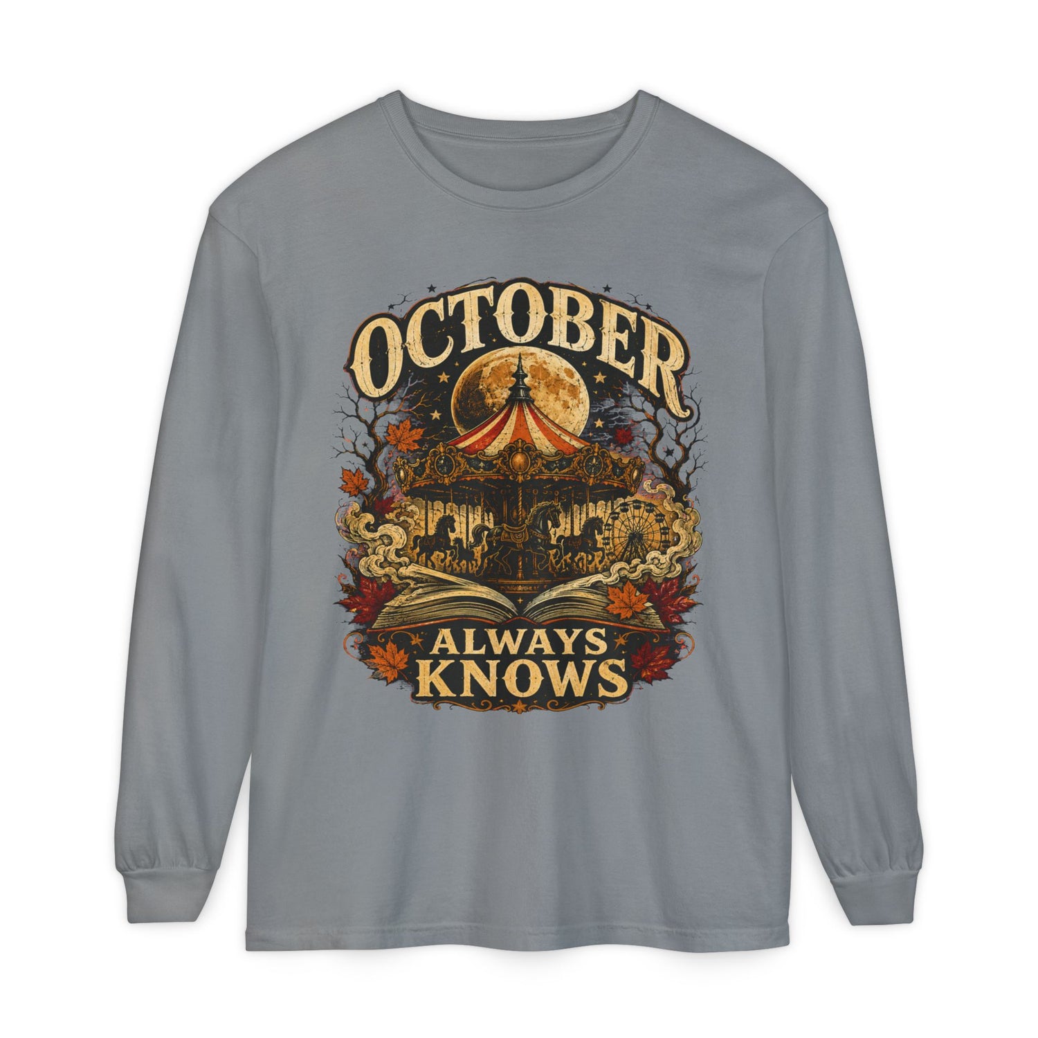 A gray long-sleeve t-shirt with a vintage-style Halloween graphic on the front. The graphic features a haunted house, a glowing full moon, a red-and-yellow circus tent, autumn leaves, and the text &